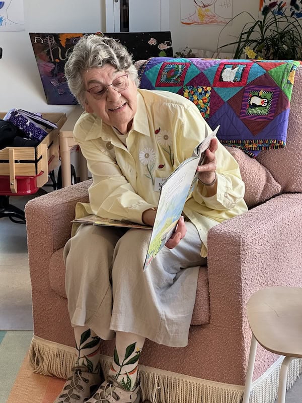 Marica reading a book in a chair.