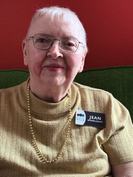 Woman with glasses and a gold-colored shirt